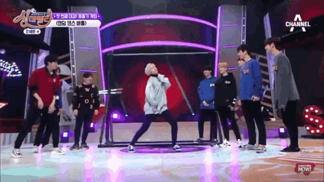 a group of young men are standing on a stage with a channel logo in the corner