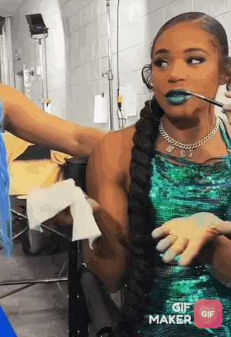 a woman in a green sequined dress is eating something with a straw .