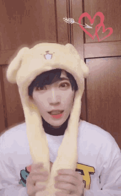 a person wearing a yellow hat with an arrow pointing to a red heart