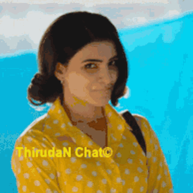 a woman wearing a yellow shirt with white polka dots and the words thiruda n chat