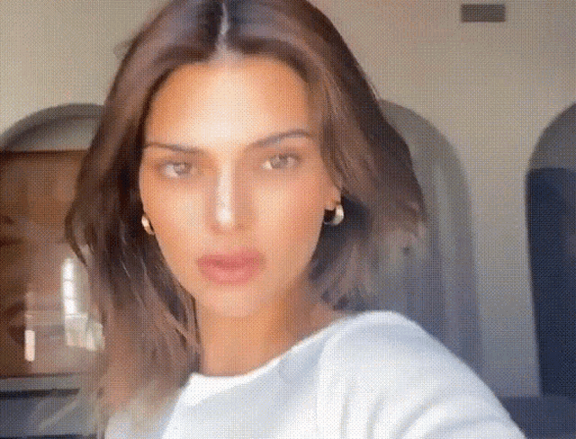 a close up of a woman 's face with a white shirt on .