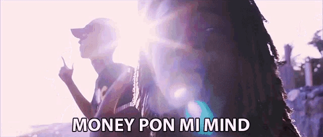 a man with dreadlocks is standing next to another man with the words money pon mi mind