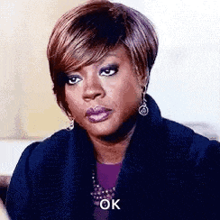 a woman wearing a black coat and earrings is making a funny face .