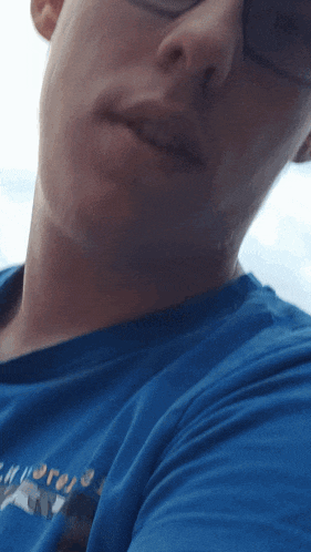 a close up of a man 's face with a blue shirt that says explorer