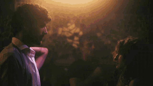 a man and a woman are looking at each other in the dark