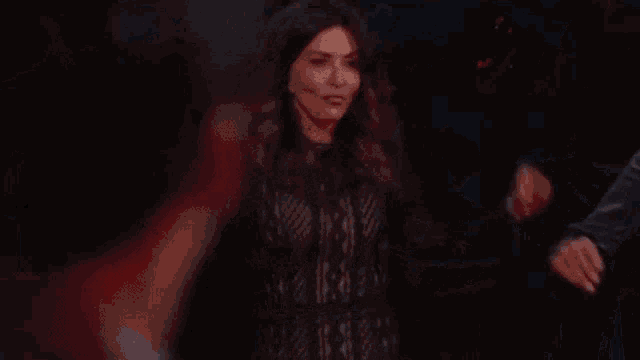 a man and a woman are holding hands in a dark room .