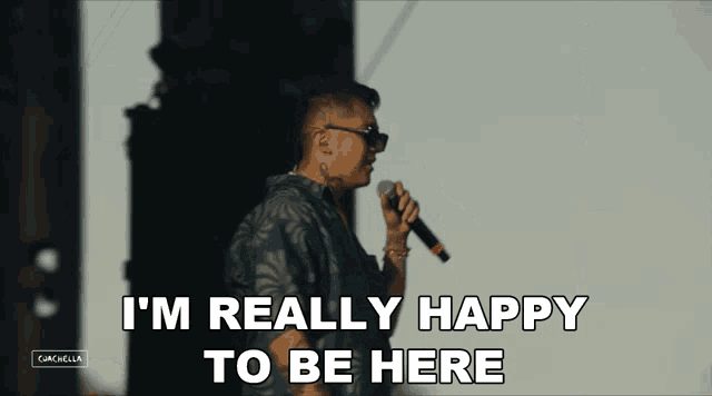 a man singing into a microphone with the words i 'm really happy to be here