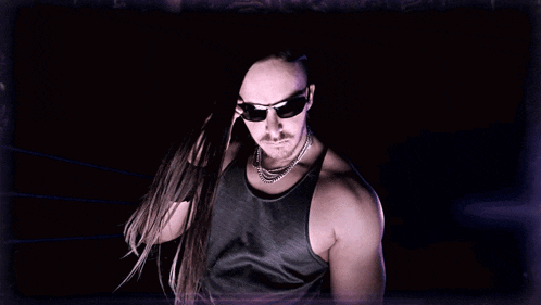 a man wearing a black tank top and a necklace