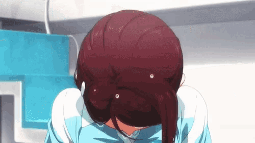 a close up of a girl with red hair covering her face with her hands .