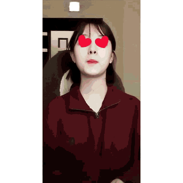 a woman wearing a red sweater has two red hearts in her eyes