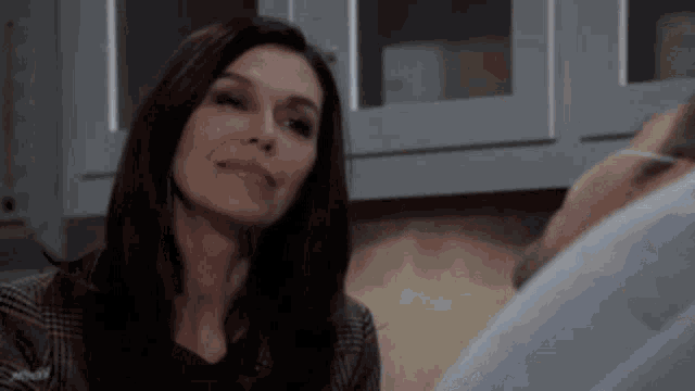a woman is sitting next to a man in a hospital bed .