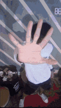 a person covering their face with their hand with the number 88 on the wall