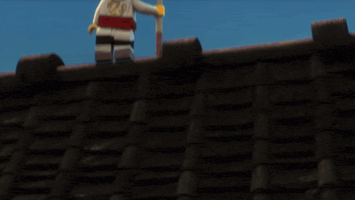 a lego man is standing on top of a roof next to a lego man with a beard