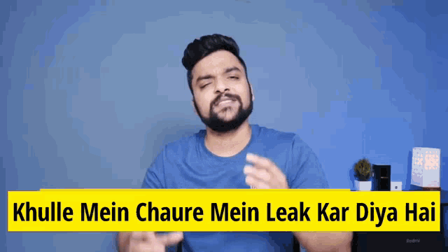 a man with a beard is standing in front of a sign that says khulle mein chaure mein leak kar diya hai ..