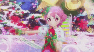 a girl with pink hair is standing in front of a christmas tree holding a christmas present .