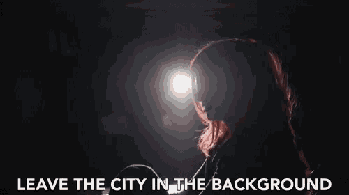 a woman in a dark room with the words " leave the city in the background " above her