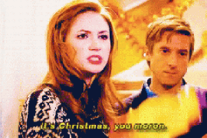a woman says it 's christmas you moron in front of a man