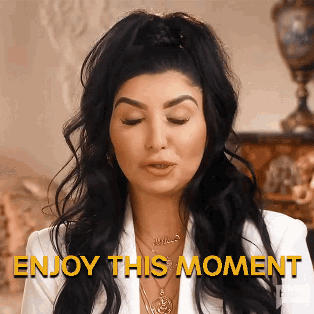 a woman in a white jacket with the words enjoy this moment below her