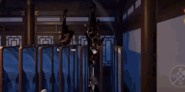 a man is hanging upside down in a room with a fence .