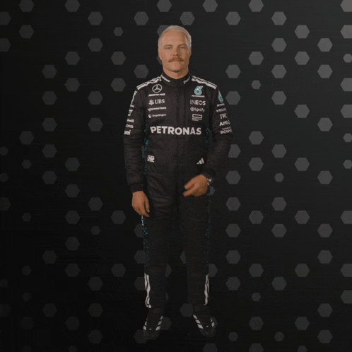 a man in a petronas suit giving the thumbs up