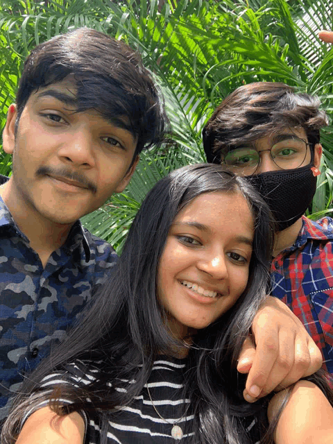 two boys and a girl pose for a picture together