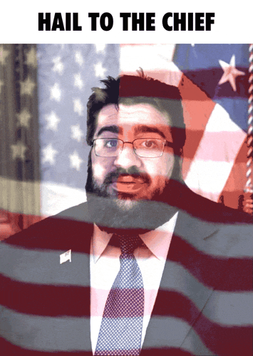 a man with glasses and a beard stands in front of an american flag with the words hail to the chief below him