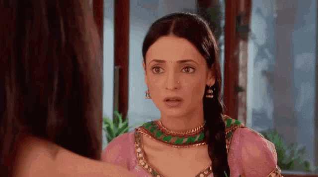 a woman in a pink dress is looking at another woman