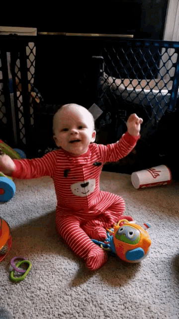 a baby wearing a red and white striped teddy bear outfit