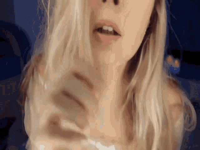 a close up of a woman 's face with her mouth open