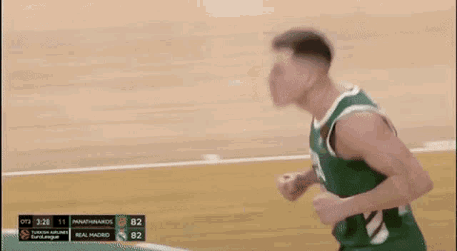 a basketball player wearing a green jersey with the number 26 on it is standing on a court .