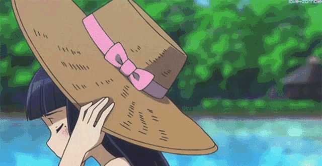 a girl wearing a large hat with a pink bow on it