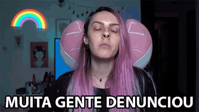 a woman with purple hair is sitting in front of a sign that says muita gente denunciou