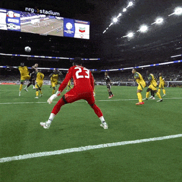 a soccer player with the number 23 on his back kicks the ball