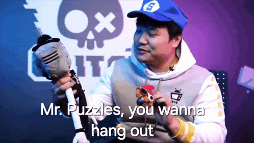a man in a blue hat is holding a stuffed animal and says mr. puzzles you wanna hang out