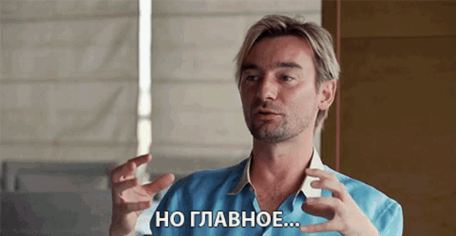 a man in a blue shirt is speaking in russian