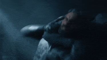 a man in a gas mask is standing in a dark room