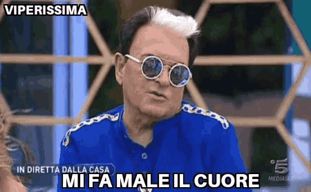 a man wearing sunglasses and a blue shirt says " mi fa male il cuore " .