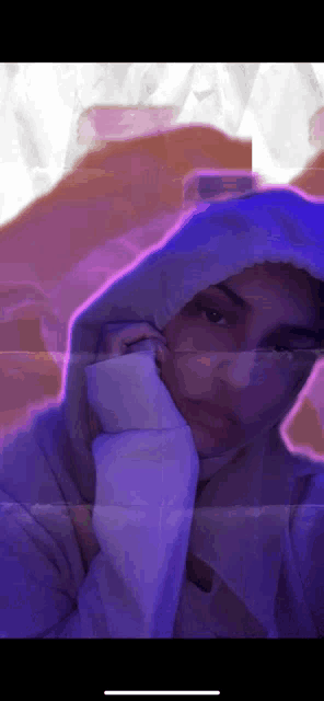 a woman wearing a hoodie is taking a selfie