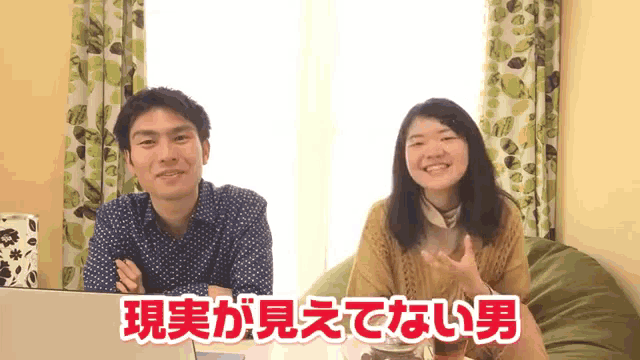 a man and a woman are sitting in front of a window with the words " 現実 が 見え て ない 男 "