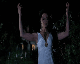 a woman in a white dress is standing with her arms outstretched at night