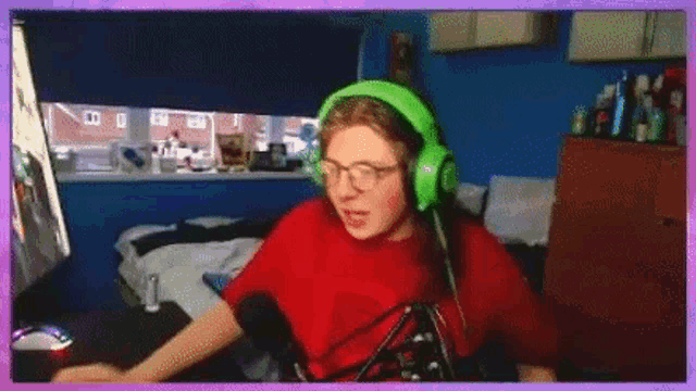 a person wearing green headphones is sitting in front of a computer monitor