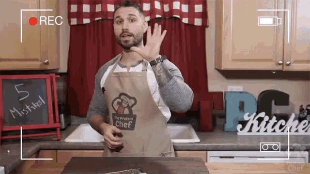 a man wearing an apron that says " the protein chef " on it