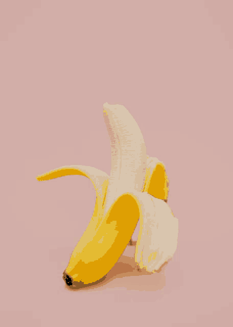 a half peeled banana is sitting on a pink background