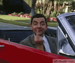 a man in a suit and tie is giving the middle finger while sitting in a red car