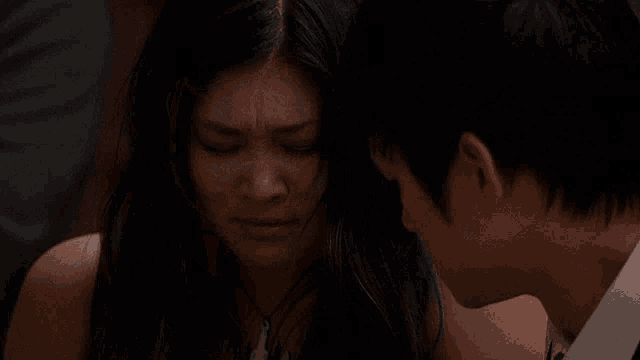 a man and a woman are looking at each other with the woman making a sad face
