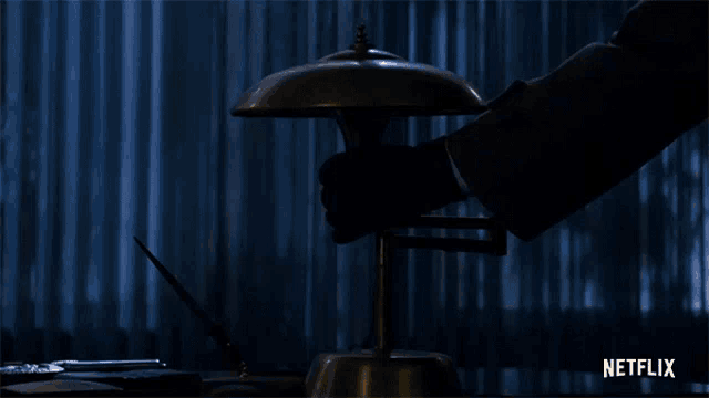 a netflix ad shows a hand holding a lamp