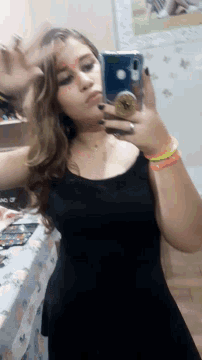 a woman is taking a picture of herself in the mirror