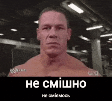 a man without a shirt is making a funny face in a gym with a caption in russian .