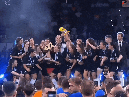 a group of people holding up a trophy with the word fc on their shirts