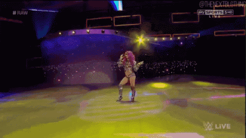 a female wrestler is dancing on a stage during a raw live event
